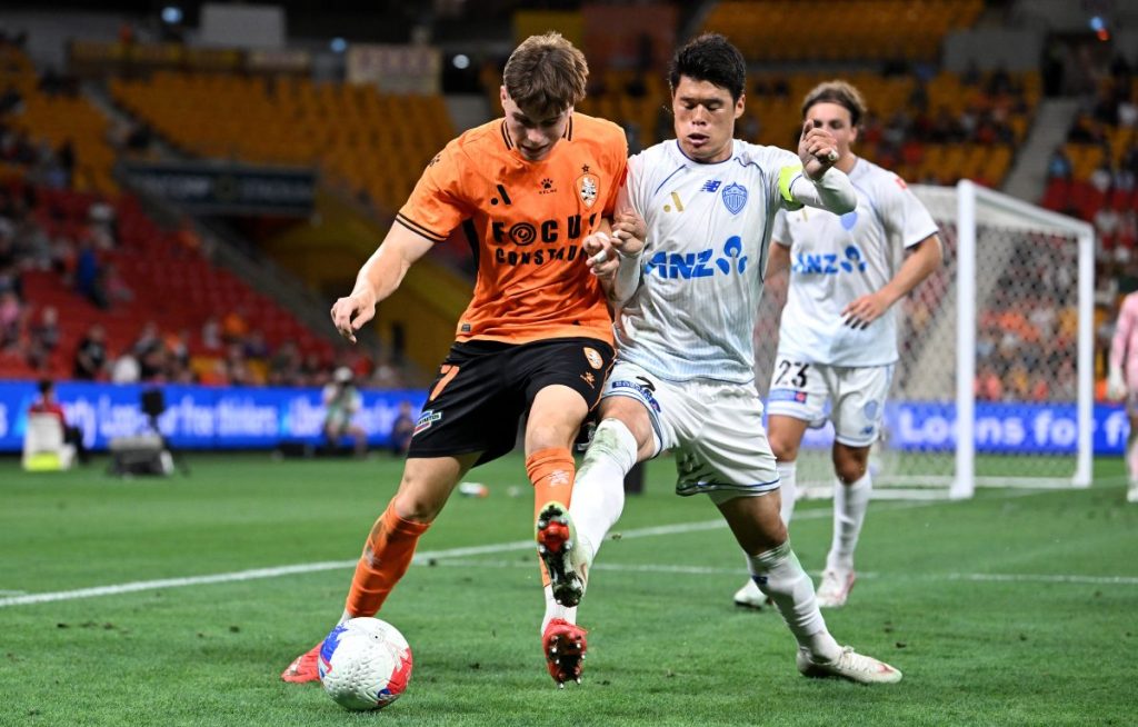 Justin Vidic of the Roar is challenged by Hiroki Sakai of Auckland FC at Suncorp Stadium.